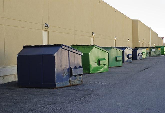 tilted front-load dumpsters being emptied by waste management workers in East Newark, NJ